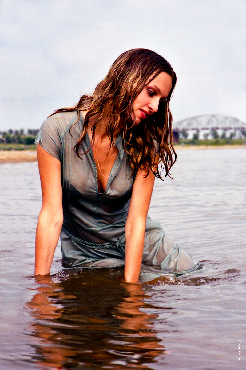 Купание в реке. Фото девушки в мокром платье, сидя в воде