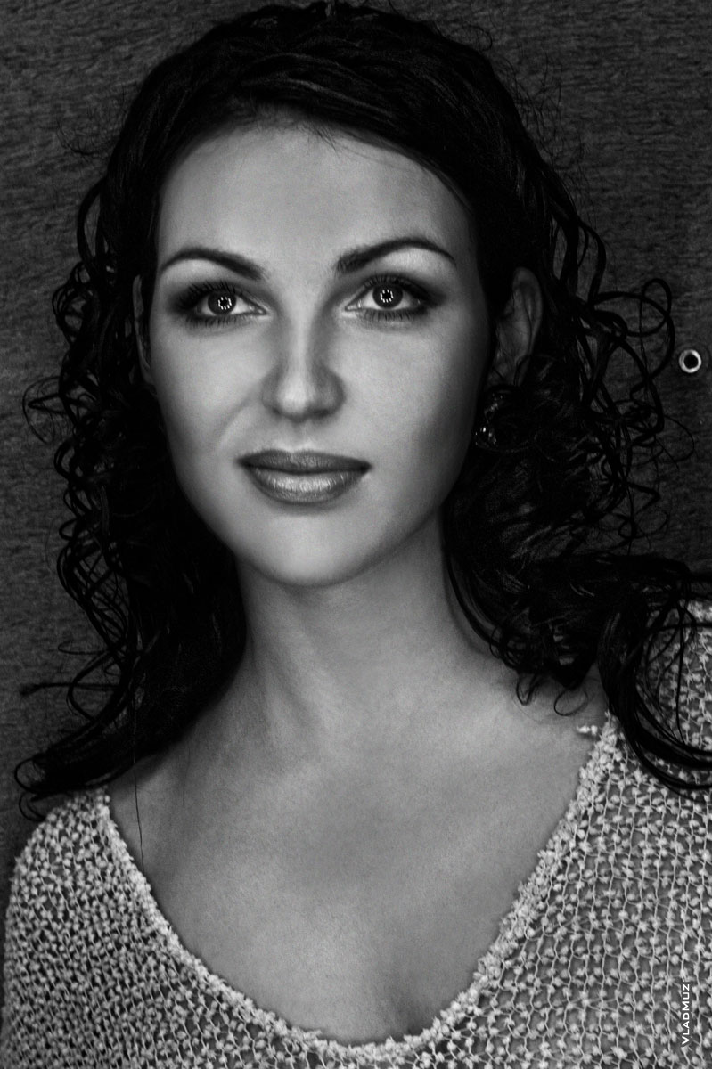 Черно-белый женский студийный фотопортрет с эффектными бликами в глазах