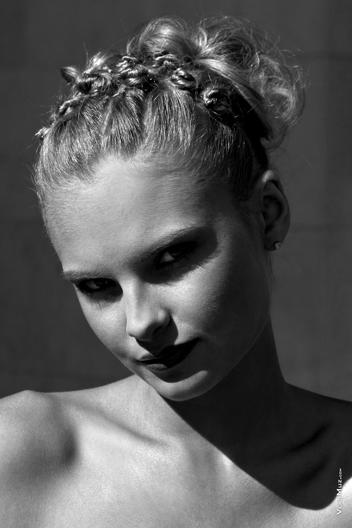 Черно-белый фотопортрет девушки-модели на улице с тенями на лице от солнца