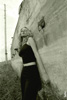 Черно-белое фото девушки, прижавшейся к бетонной стене