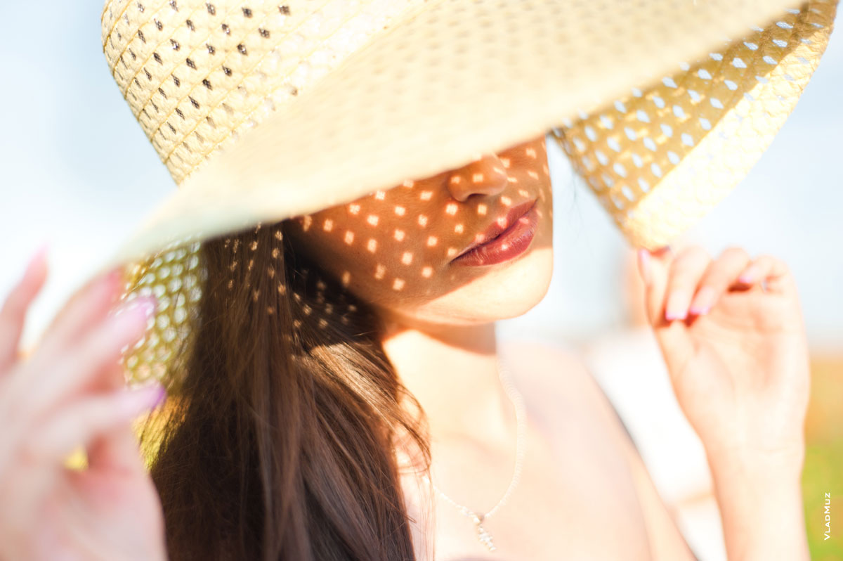 Летний лайфстайл: девушка в шляпе, летнее фото с солнечными бликами на лице
