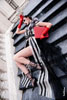 Модный образ девушки-модели в красных перчатках, лежа на лестнице в странной позе в полный рост, с красной папкой в руке