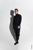 Фото мужчины-модели в студии на белой циклораме в полный рост с черной тенью на белом фоне