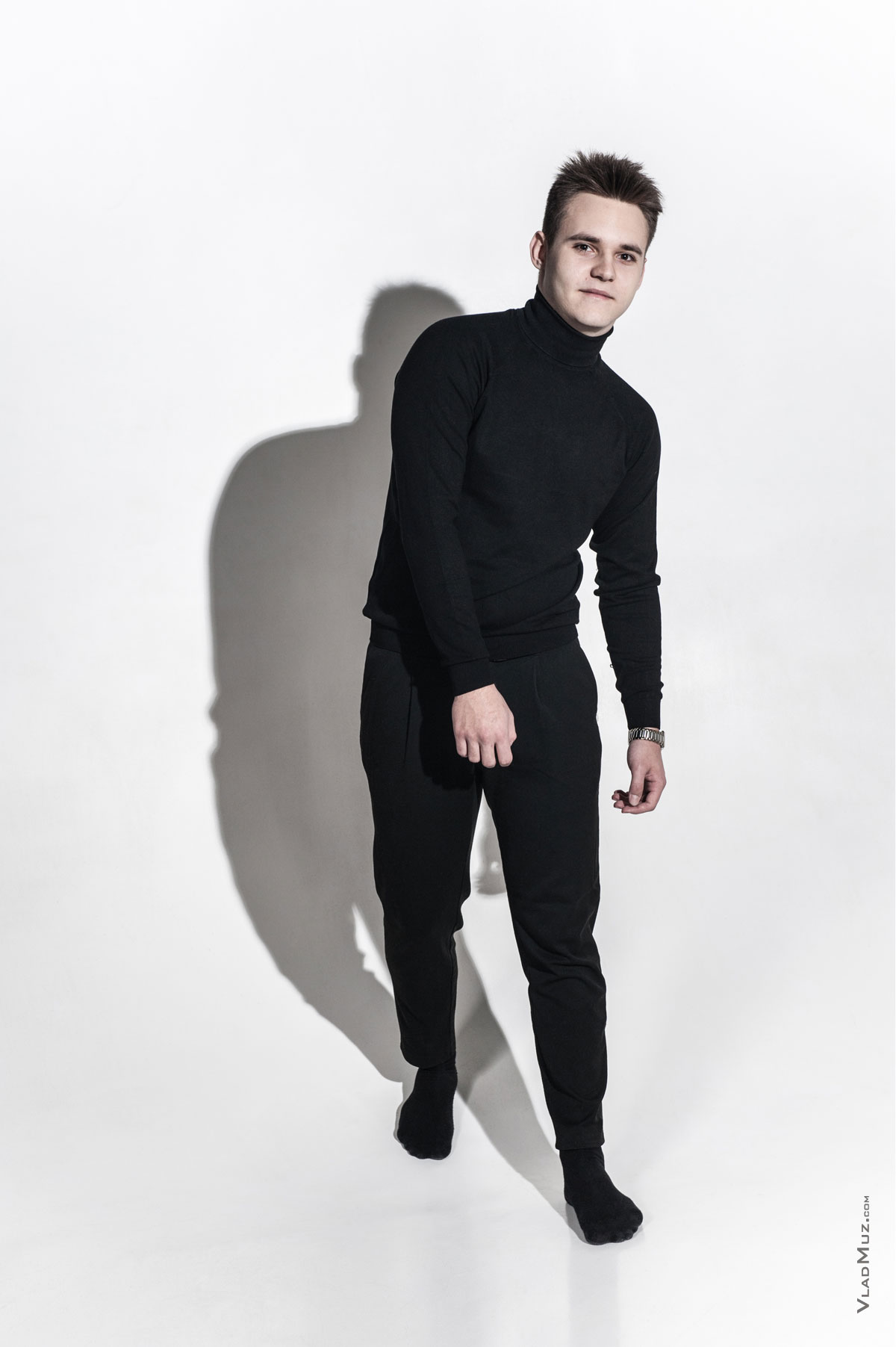 Фото мужчины в черном в идущей позе в полный рост, на белой циклораме, из мужского модельного портфолио