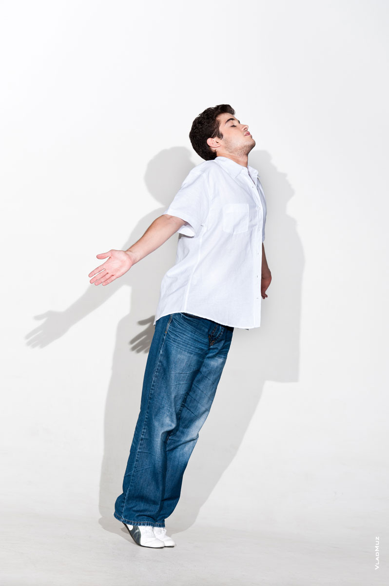 Фото мужчины-модели на белом фоне в полный рост в летящей позе